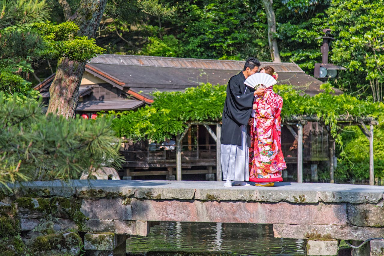 A couple dressed in traditional kimono on a stone bridge in Kurashiki, Okayama.